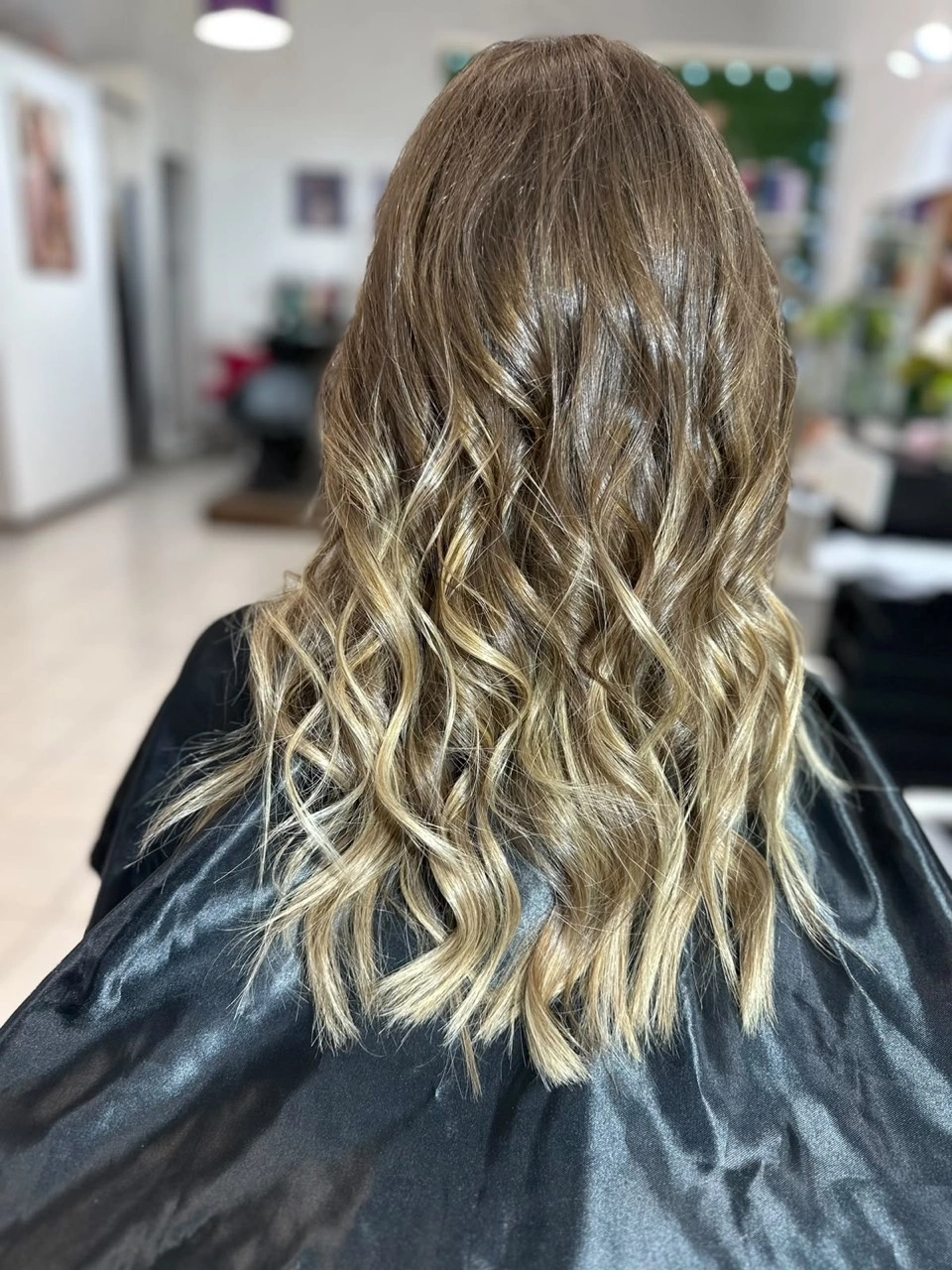 Cabello con raíz castaña, reflejos claros y ondas, foto compartida por Cecilia